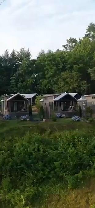 A cinematic aerial frame of the cabins above the French Broad River, cut for a vertical reel